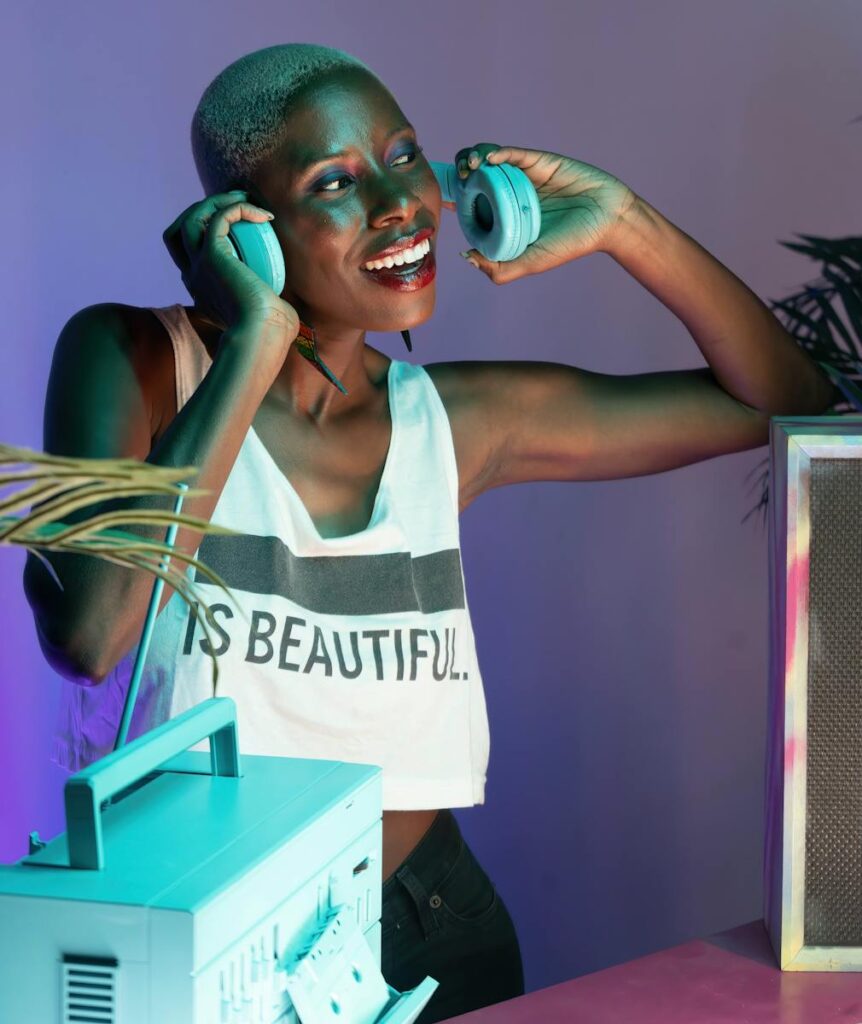 Colorful portrait of a joyful woman DJing indoors with headphones.